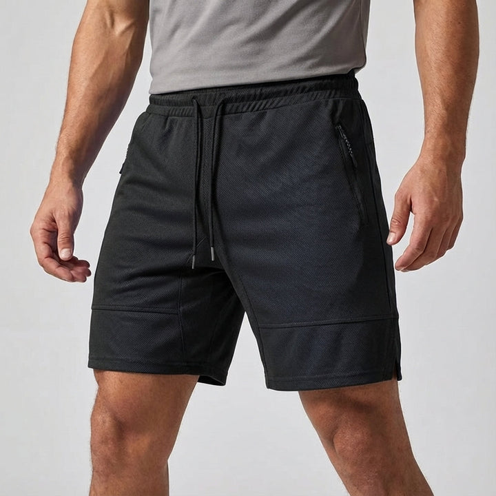 Close-up of men's athletic shorts in black, highlighting the zipper pocket and breathable, quick-dry material.