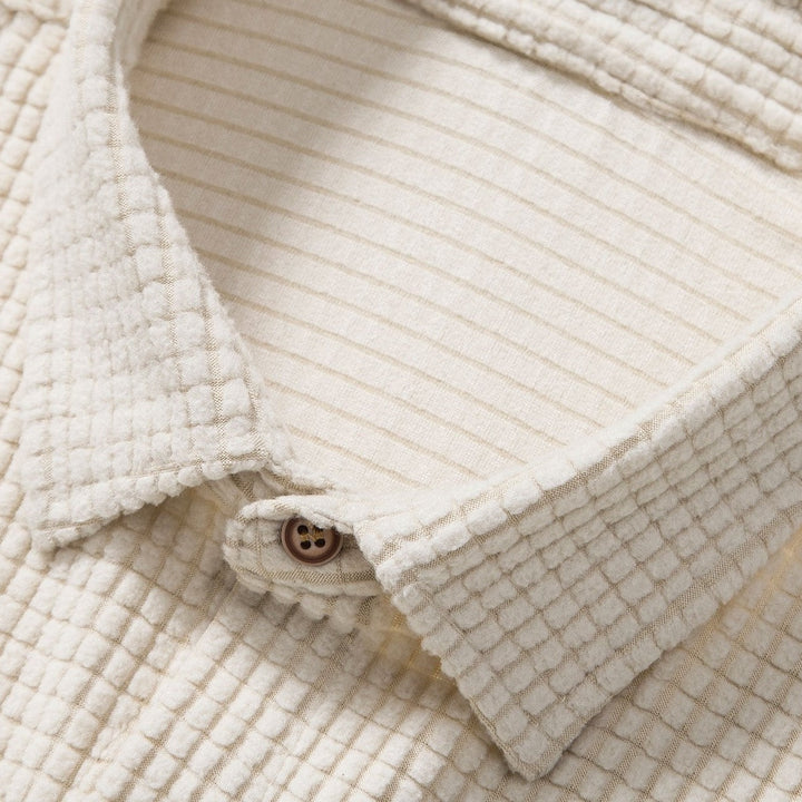 Men's two-piece waffle knit outfit, featuring breathable polo & shorts for summer comfort.