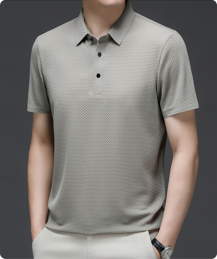 Man walking confidently in a quick-dry Matteo polo shirt, blending style with ultimate comfort & versatility.