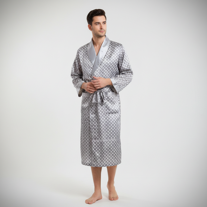 Front view of a men's black satin bathrobe, 'Marius', adorned with elegant gold patterns and a tie.