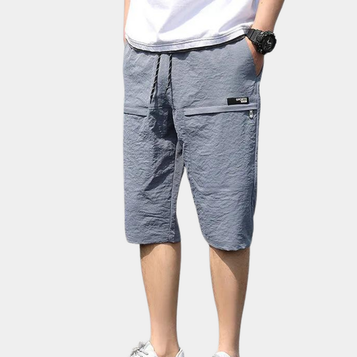 Pink men's relaxed fit cargo shorts, a fashionable choice for summer and holiday outfits.