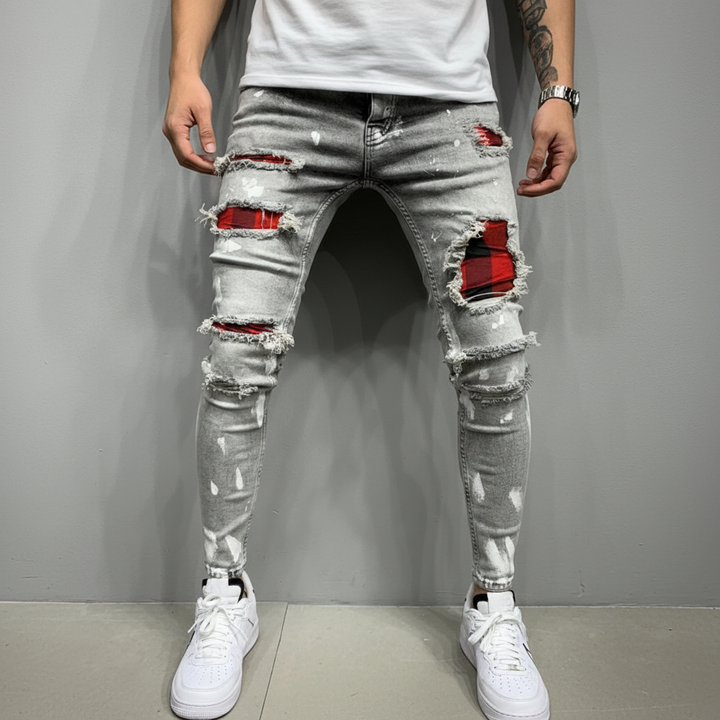 Detailed shot of patched and ripped sections on men's slim fit denim jeans, a fashion statement.