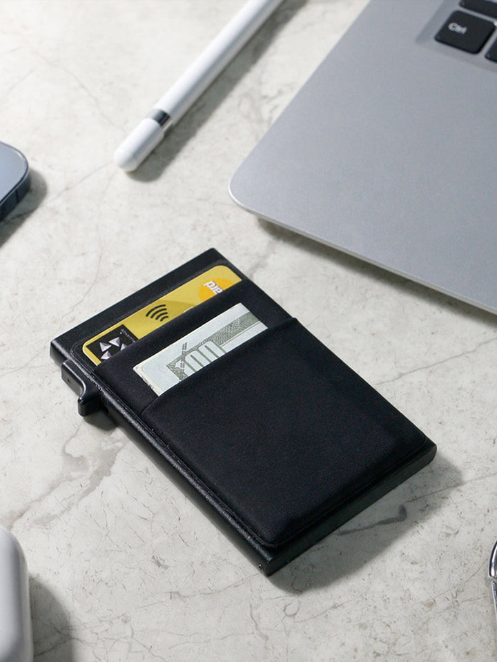 Detail of the smooth finish on a men's metal RFID blocking card holder, minimalist style