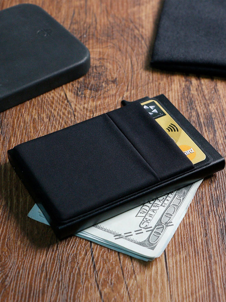 Hand holding a men's slim metal RFID wallet, showcasing its ergonomic design and size