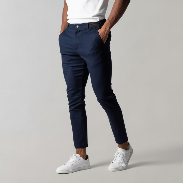 Stack of folded Mika Men's chino trousers, highlighting color range and premium cotton material