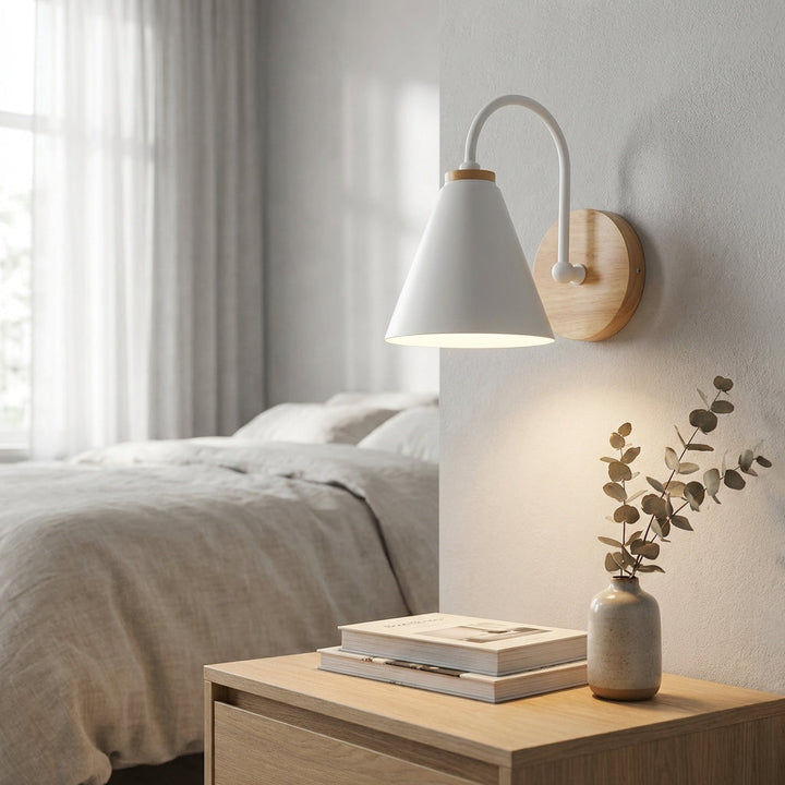 Modern downward cone wall sconce with a sleek metal shade and wood accent, providing ambient lighting.