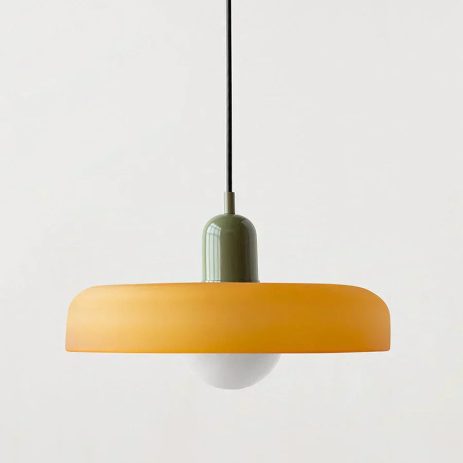 Sleek glass pendant light, brass accents, adds warmth to modern decor.
