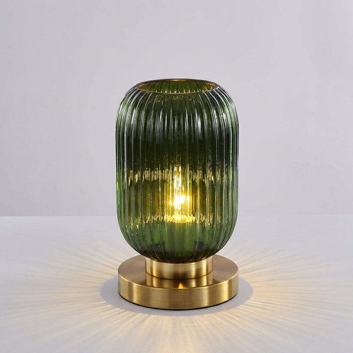Glintora ribbed glass table lamp, a modern home decor piece, casting soft light in a living room setting.