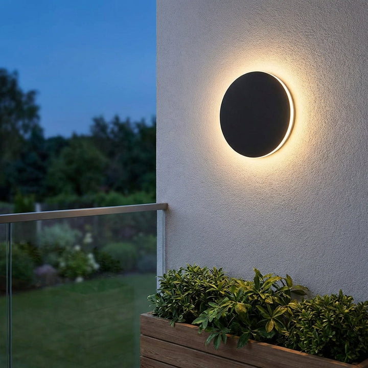 Modern round stainless steel outdoor wall light, perfect for illuminating a patio