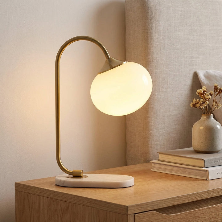 Modern rounded table lamp by Melluma with frosted glass shade & metal base, perfect for ambient lighting.