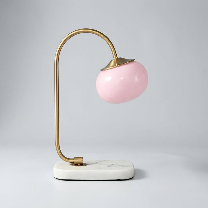 Contemporary Melluma rounded table lamp with a dark metal base and an elegant, luminous glass globe.