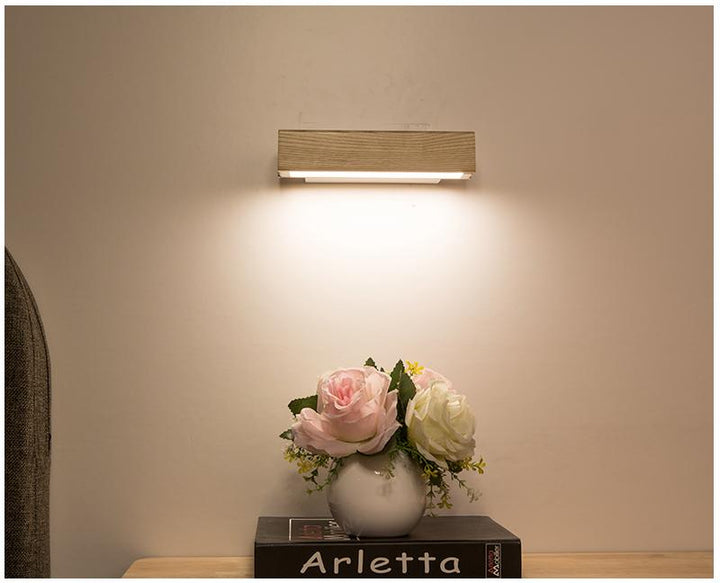 Stylish wooden LED wall light, adjustable and modern, ideal indoor lighting for bedroom and living room.