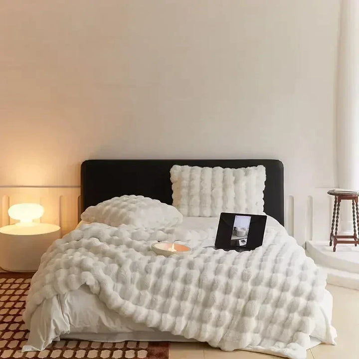 Textured cream faux fur blanket, showcasing its softness and inviting comfort for home styling