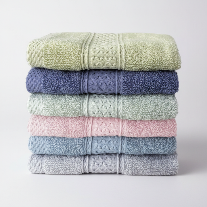 Soft, white six-piece cotton towel set, perfectly folded, showcasing quality bathroom linens.