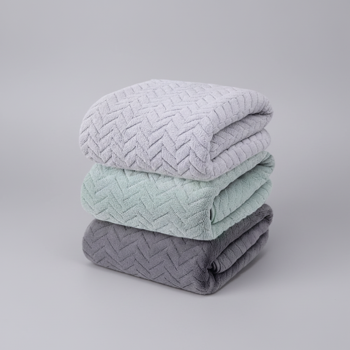 Folded gray unisex microfiber bath towels, absorbent & easy care, perfect for a modern bathroom.