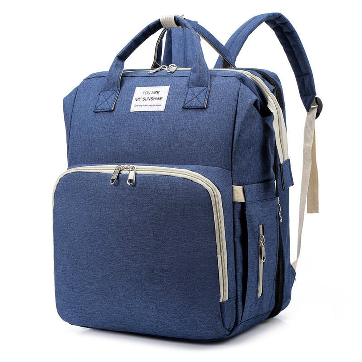 Waterproof baby travel bag with changing mat and attached portable bed, grey modern design.