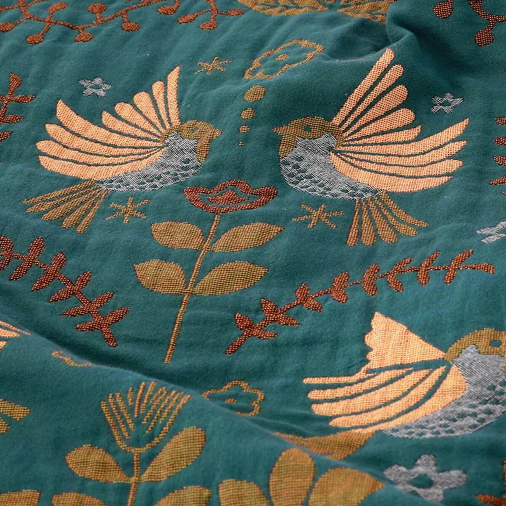 Soft cotton reversible throw blanket featuring a Nordic bird design, perfect for adding warmth to any room.