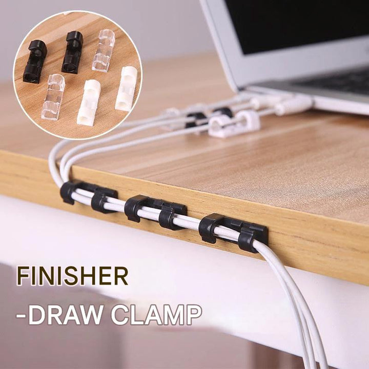 Self-adhesive wire clamp clips securing computer cables neatly along a desk edge, decluttering a home office.