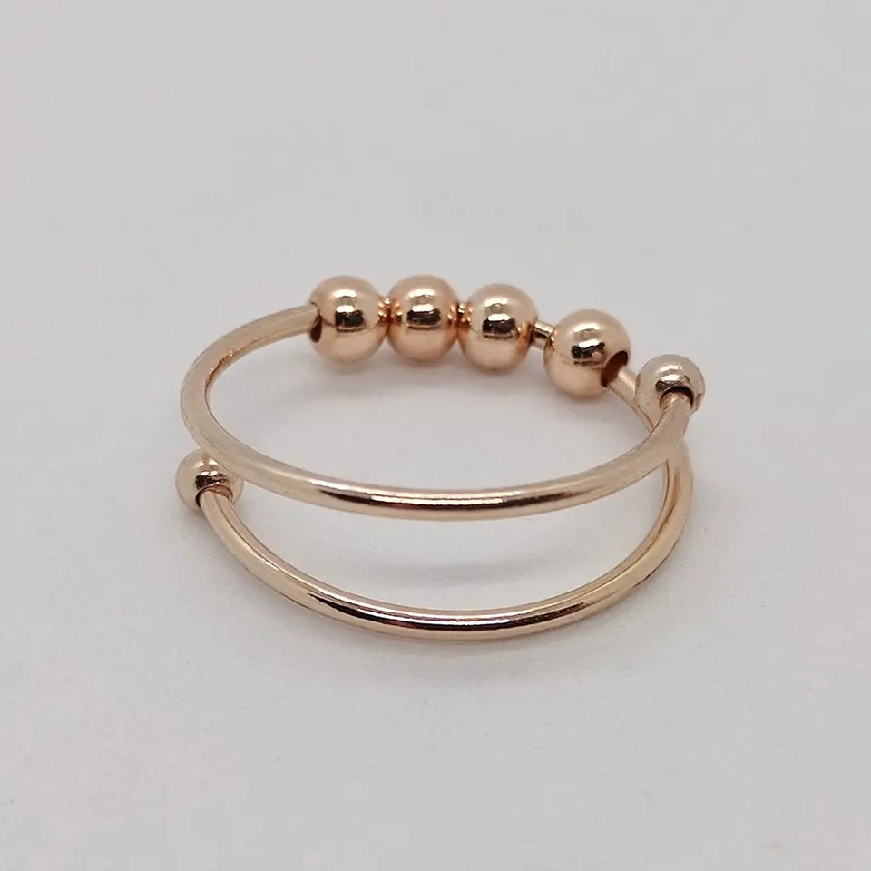 Close-up of a women's CalmSpin adjustable fidget anxiety ring, spinning for stress relief & meditation.