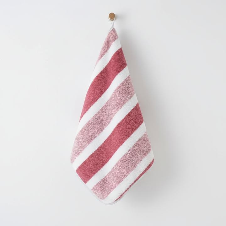 Close-up of fluffy coral fleece striped towel, showcasing softness and absorbency, quick dry