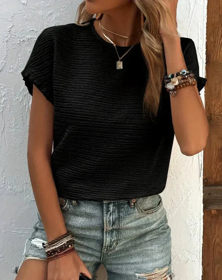 Detail shot of the crew neck collar of a women's soft cotton t-shirt, comfort fit.