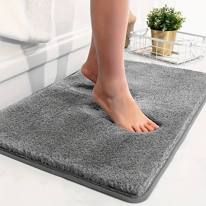 Soft grey bath mat with geometric pattern, non-slip & absorbent for luxury bathroom comfort.