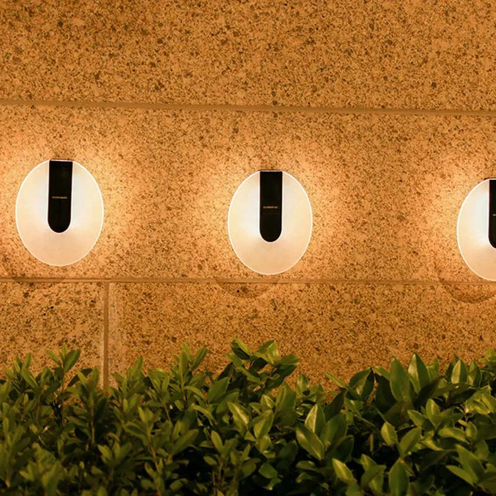 Weatherproof Solenyx round LED wall sconce providing bright, energy-efficient light for a patio