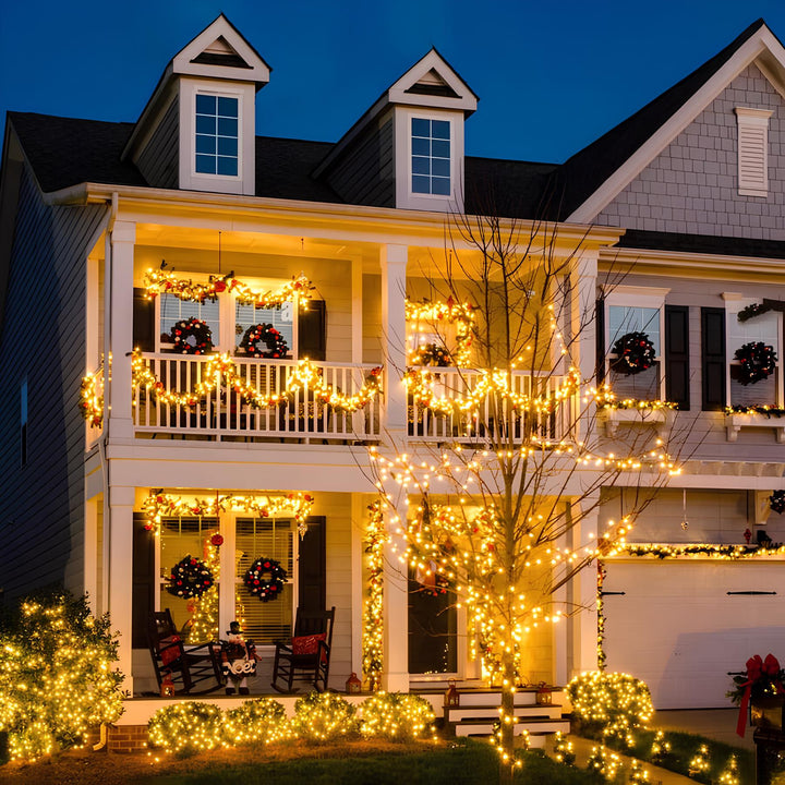 Long strand of SoliGlow solar powered LED string lights hanging from tree branches, waterproof.