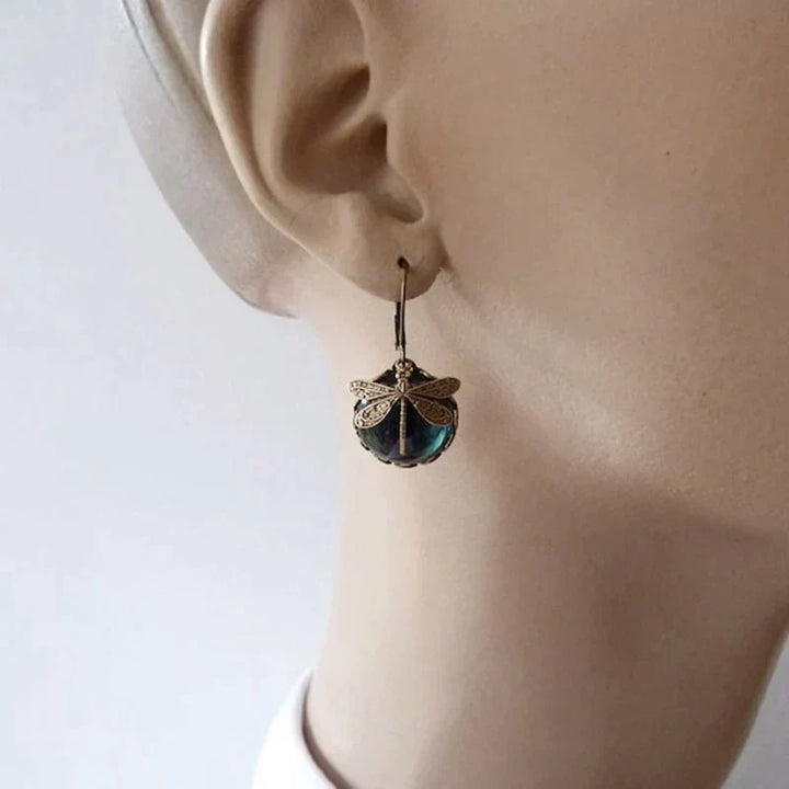 Intricate crystal detailing on women's antique gold drop earrings, adding a touch of vintage elegance.