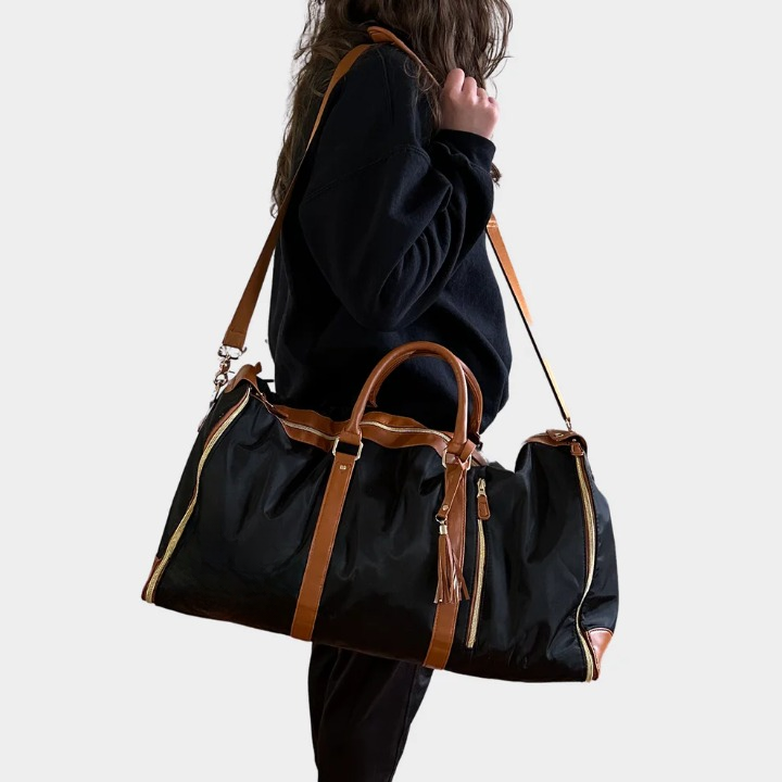 Elegant women's vegan leather travel duffel with secure zippers and sturdy straps, functioning as a 2-in-1 garment bag.