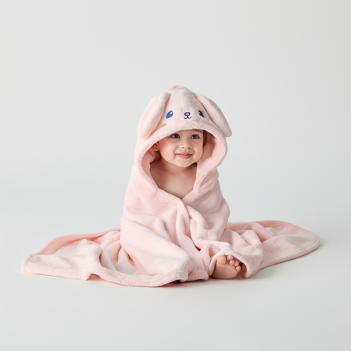 Happy toddler wrapped in a cozy green SnuggleDino hooded animal bathrobe, playing