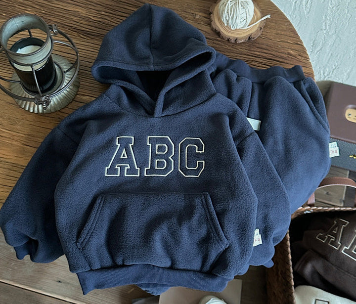 Toddler in warm fleece-lined winter hoodie and trousers set, ideal for kids' play clothes.