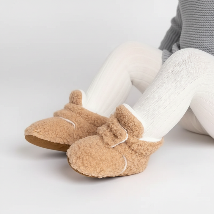 Child's feet in cozy grey teddy fabric slipper socks with anti-slip grip, designed for safety and comfort.