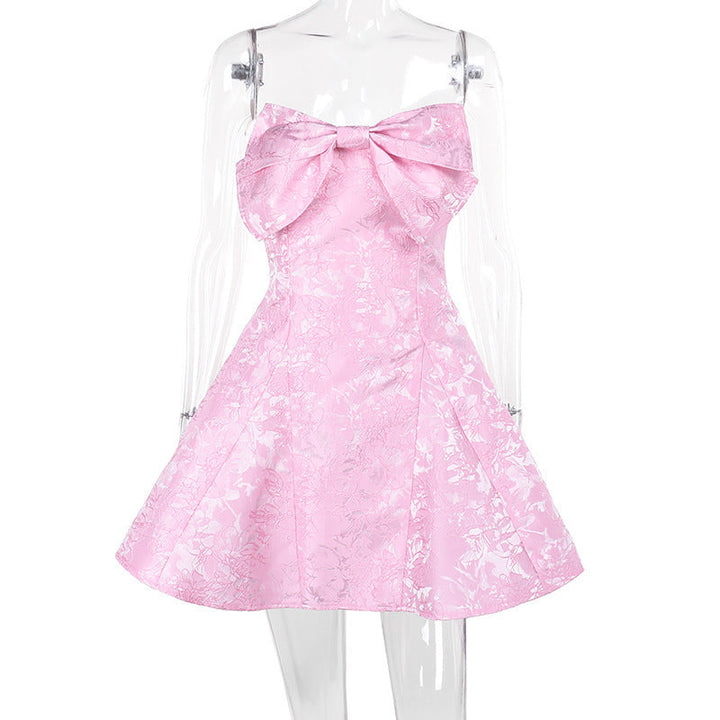 Fashionable pink off-shoulder mini dress with a bow accent. A trendy women's party dress and summer essential.