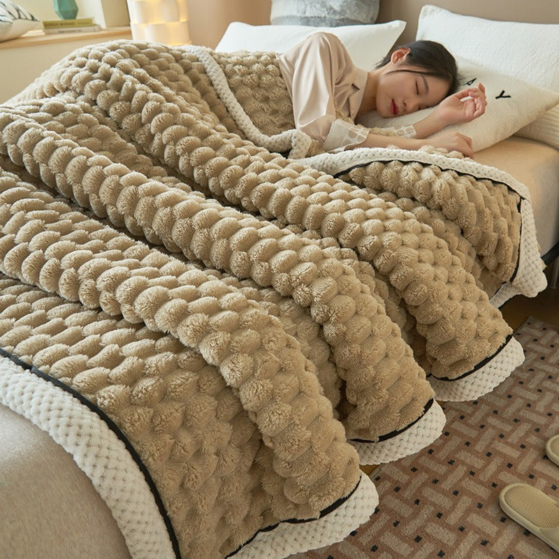 Comfy flannel fleece throw blanket neatly folded on a living room sofa, ready for a warm & cozy evening.