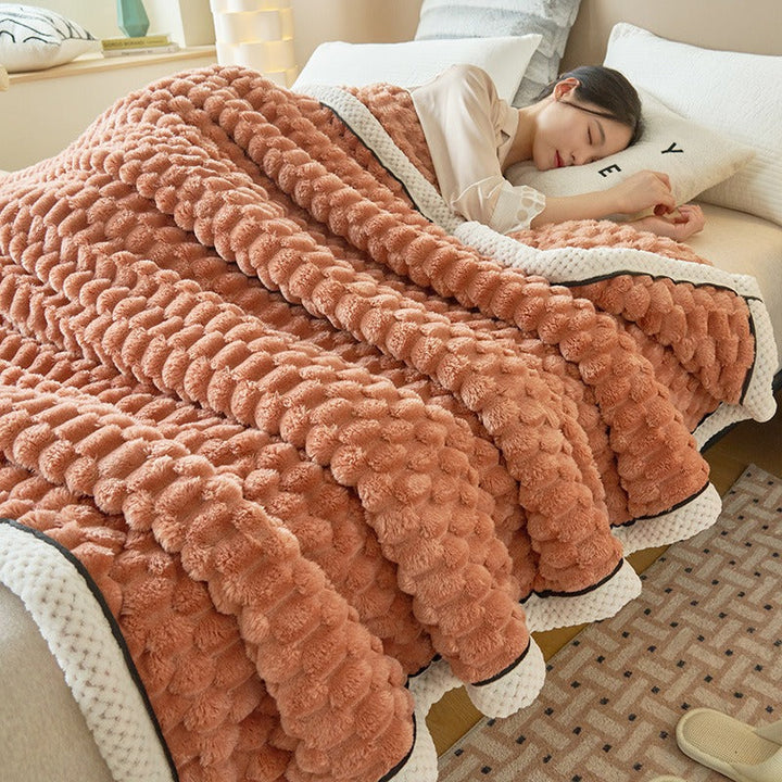 Warm flannel fleece throw blanket draped over a bed, adding a soft, cozy touch to bedroom decor.