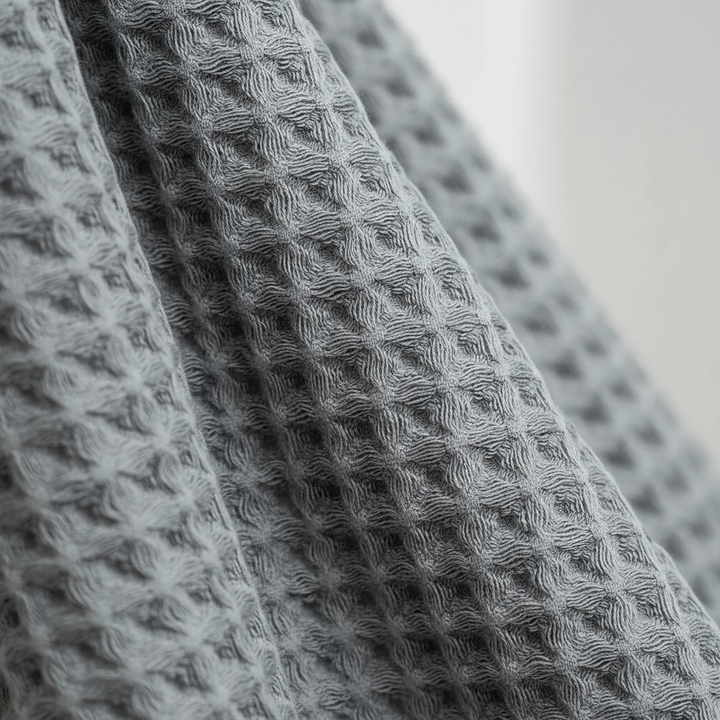 Stack of folded FreshWrap Pima cotton waffle towels, demonstrating their plushness and elegant bathroom aesthetic