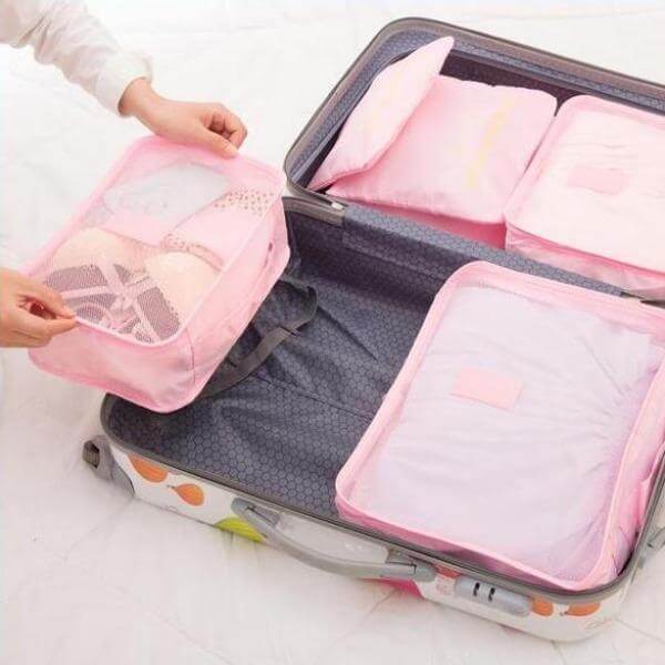 Unisex travel packing cube filled with clothes, ideal for luggage organization