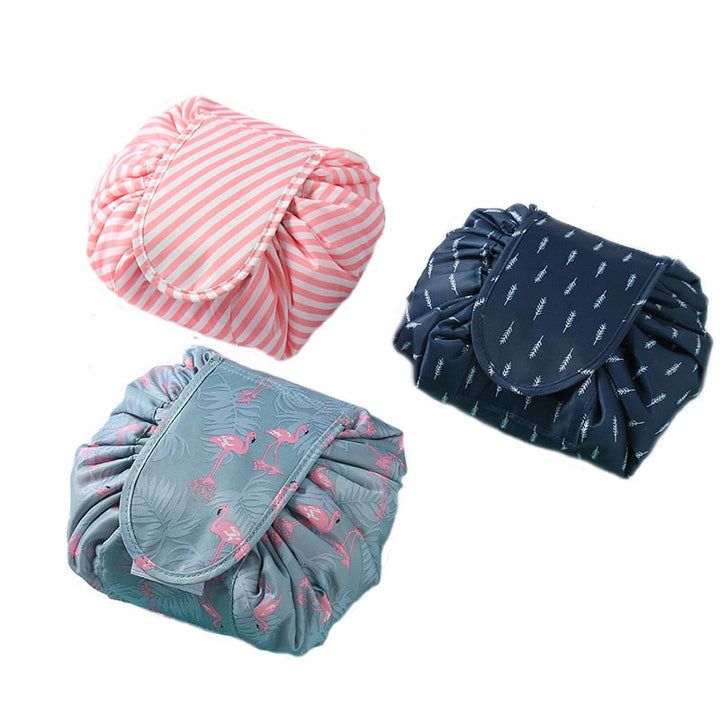 Unisex black drawstring cosmetic toiletry bag, open, with makeup brushes and bottles inside