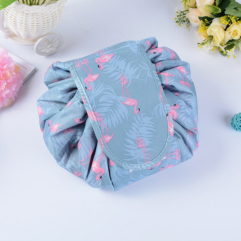 Two portable drawstring cosmetic bags, one open black and one closed grey, for travel organization