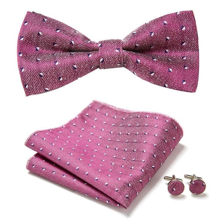 Close-up of a floral bow tie set with delicate pattern, includes pocket square and cufflinks, perfect for formal events.