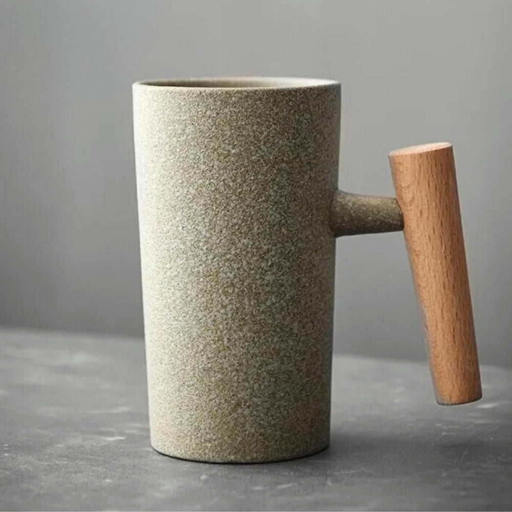 Side view of a Nordic earthenware latte mug with an earthy finish & distinctive wooden handle, kitchenware.