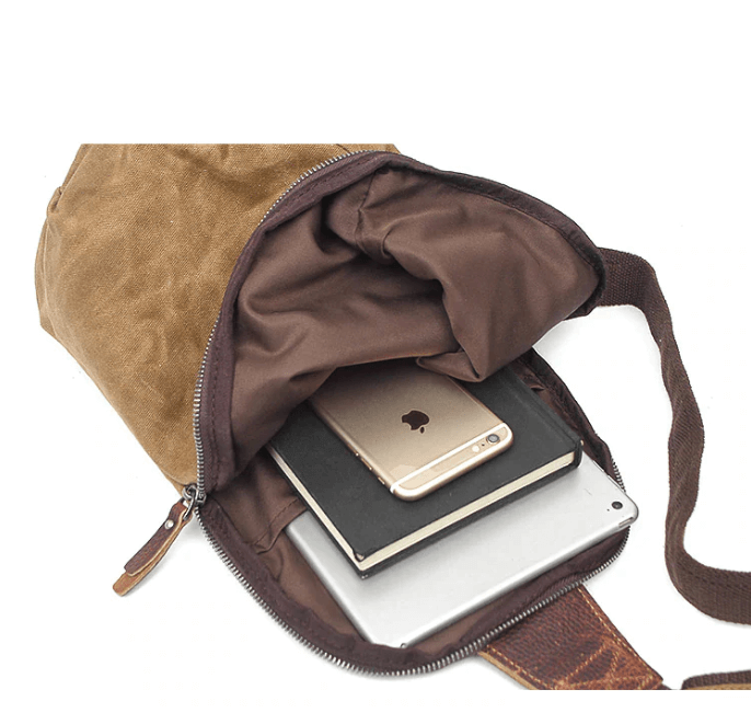 Close-up of anti-theft pocket on water-resistant crossbody bag, secure zipper, gray canvas fabric