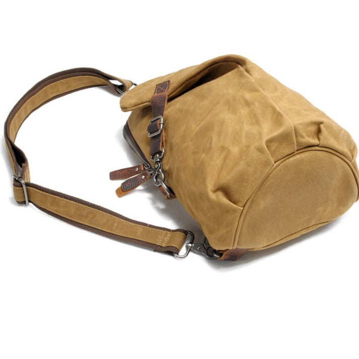 Flat lay of a water-resistant travel bag, anti-theft features, essentials like phone and wallet inside