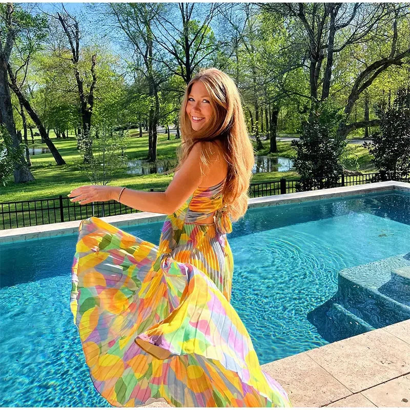 Feminine Vivienne floral summer dress with vibrant print, deep neckline, and stylish bow-back design.