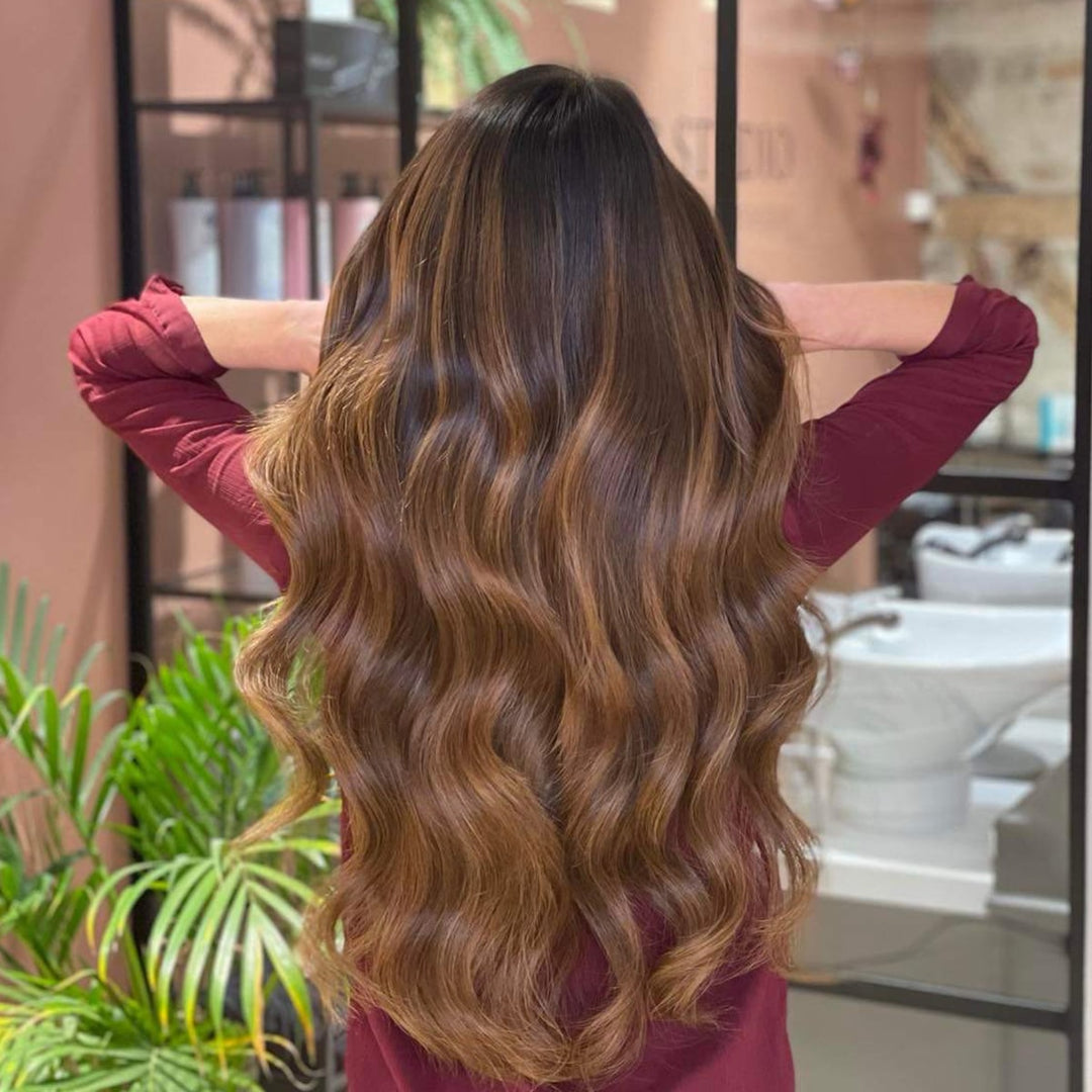 Women's warm brown balayage tape-in human hair extensions, enhancing natural volume, length & style.