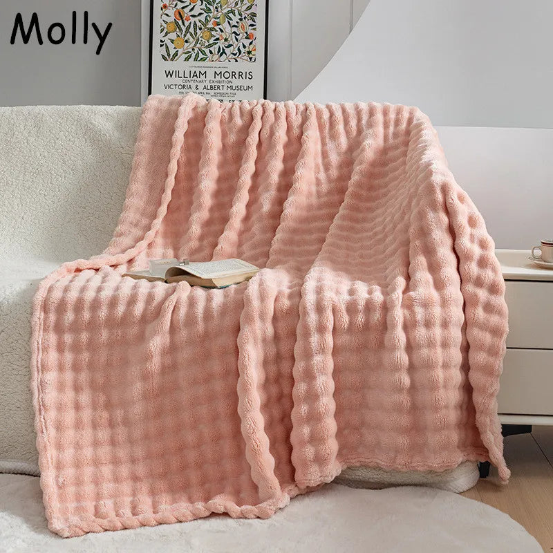 Warm flannel plush blanket in a neutral tone draped over a sofa, perfect for cozy home decor.