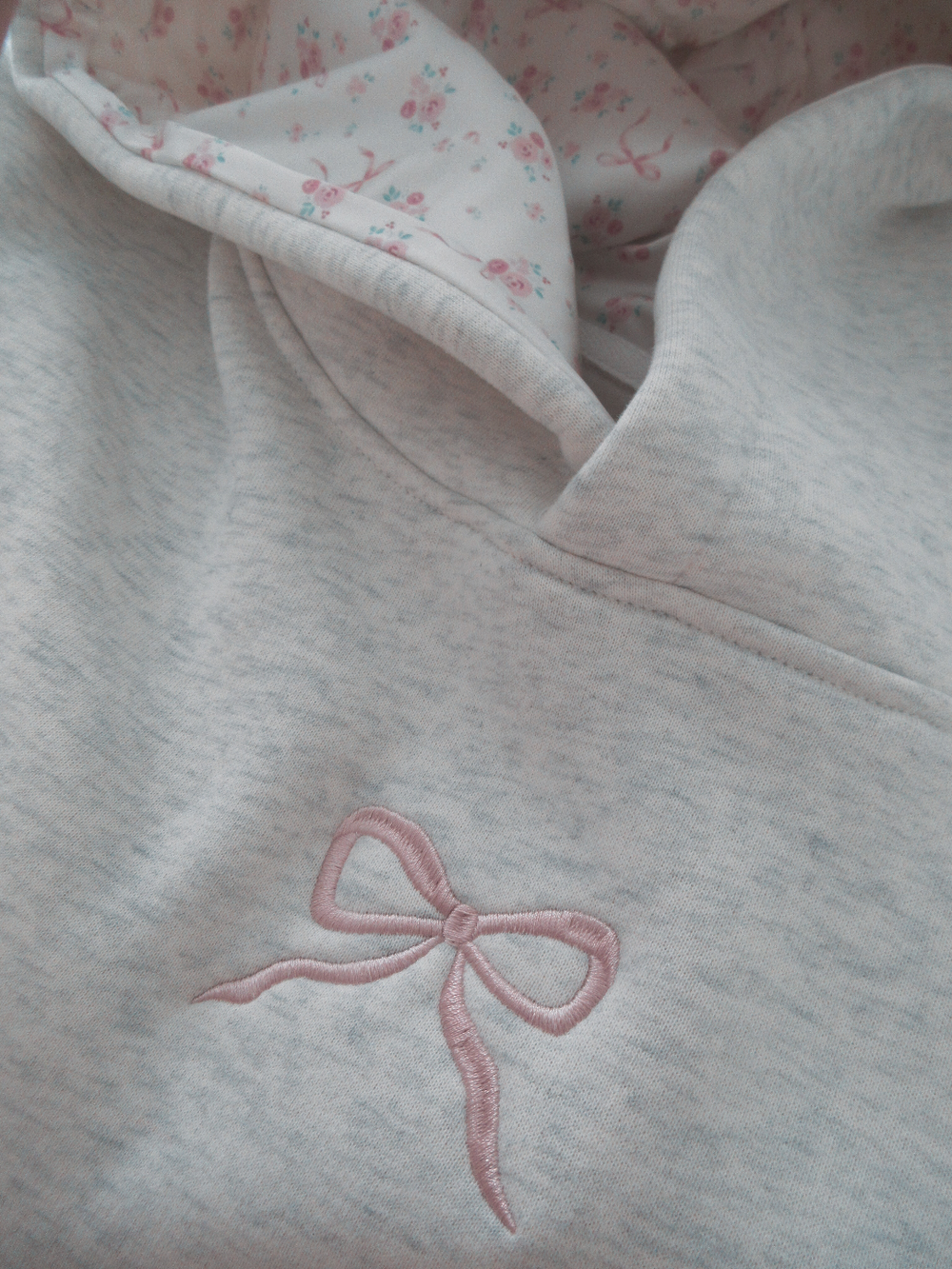 Stylish white women's hoodie with a unique pink bow accent. Versatile for everyday fashion & comfort.