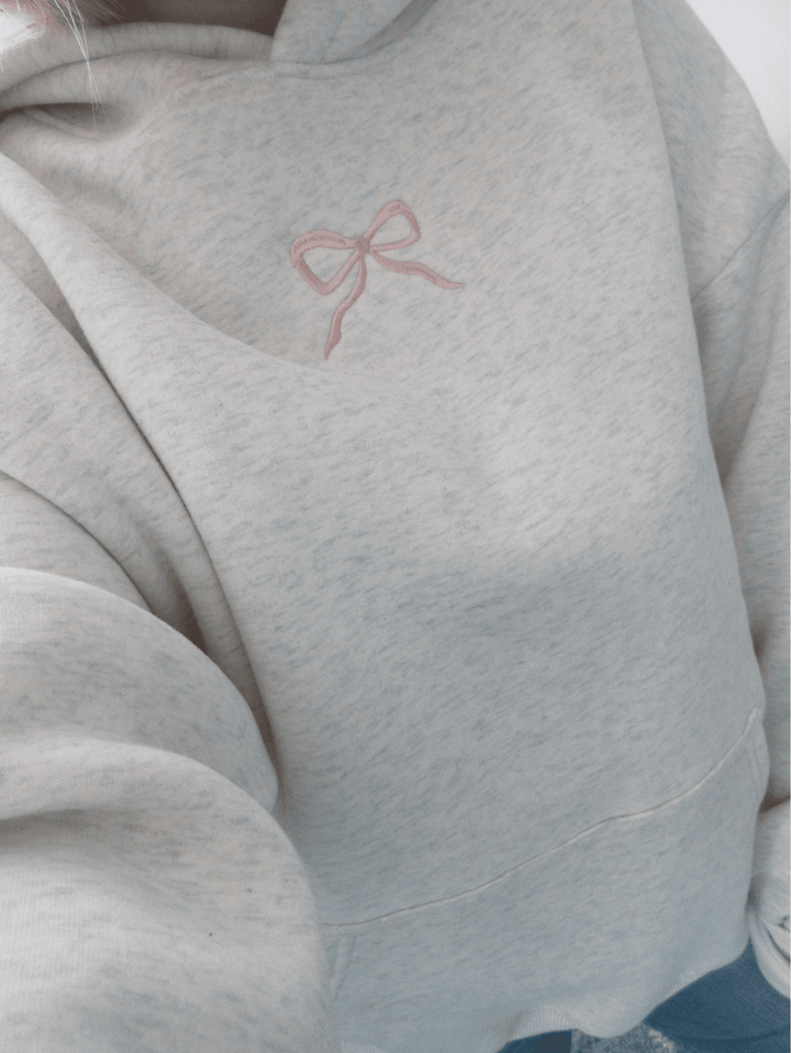 Effortless white Elodie hoodie for women, soft, cozy, and perfect for relaxed casual wear with a pink bow.