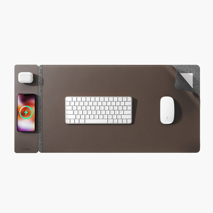 Dual-surface wireless charging desk mat. Reversible vegan leather & felt for office organization & gadget power.
